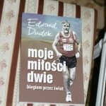 Leżąca na krześle książka z napisami na okładce: Edward Dudek, moje dwie miłości, biegiem przez świat