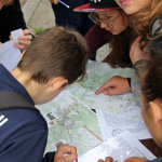 Grupka dzieci pochylona nad mapami Krynicy - Zdroju.