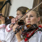 Dwie kobiety grające na skrzypcach.