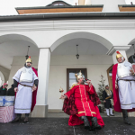 42. Mężczyzna w przebraniu króla siedzi na tronie, obok mężczyźni w strojach rzymskich żołnierzy, z tyłu ludzie.