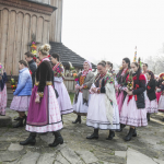 Procesja złożona z kobiet w strojach ludowych, niektóre niosą palmy.