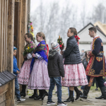 Ludzie w strojach regionalnych wchodzący do kościoła.