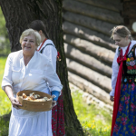 Trzy kobiety, jedna z nich ubrana na biało, dwie w strojach ludowych.