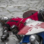 Leżący na ziemi mężczyzna w przebraniu żołnierza.