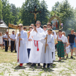 Procesja wokół świątyni, po bokach idących lektorów ludzie.