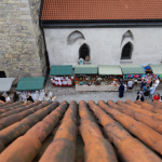 Widziany z lotu ptaka fragment dachu, na dole stoiska z rękodziełem i ściany kościoła.