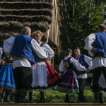 Tańcząca grupa osób w strojach regionalnych.