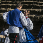 Tańcząca grupa osób w strojach regionalnych.