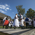 Tańcząca na scenie grupa osób w strojach regionalnych.