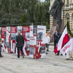 Kilku mężczyzn oglądających plansze wystawowe.