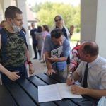 Mężczyzna składa autograf w albumie