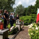 Osoby stojące na cmentarzu.