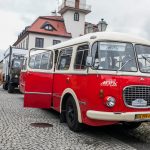 Zabytkowy autobus stojący na rynku miasteczka galicyjskiego, w tle budynek ratusza.