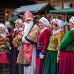 Święty Mikołaj w otoczeniu kobiet w strojach regionalnych.